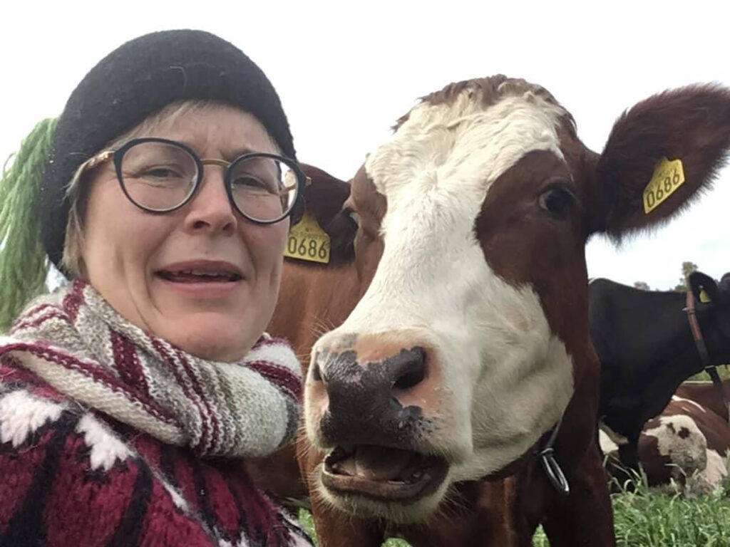 Gudny på Borhaug gård med en ku